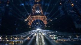 A photograph taken from an helicopter on July 26, 2024 shows an aerial view of the Eiffel Tower and the Olympics Rings lightened up during the opening ceremony of the Paris 2024 Olympic Games in Paris. (Photo by Lionel BONAVENTURE / POOL / AFP)
