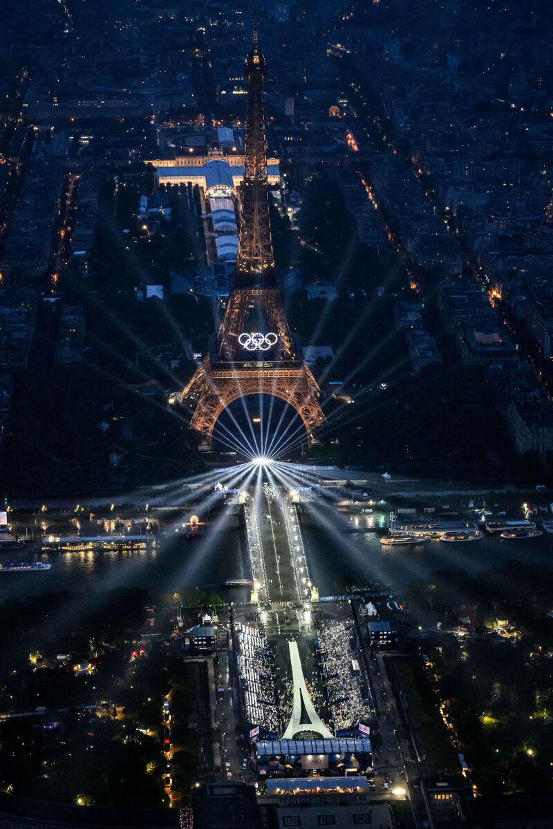 A photograph taken from an helicopter on July 26, 2024 shows an aerial view of the Eiffel Tower and the Olympics Rings lightened up during the opening ceremony of the Paris 2024 Olympic Games in Paris. (Photo by Lionel BONAVENTURE / POOL / AFP)